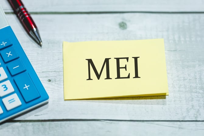 Mercado Pago: bloquinho de notas escrito “MEI”, ao lado de uma calculadora e uma caneta, representando como emitir nota MEI.