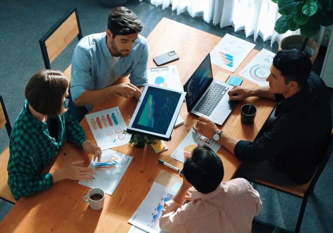 Mercado Pago: Equipe reunida em um ambiente corporativo analisando gráficos e relatórios, discutindo estratégias de gestão empresarial para otimizar resultados.