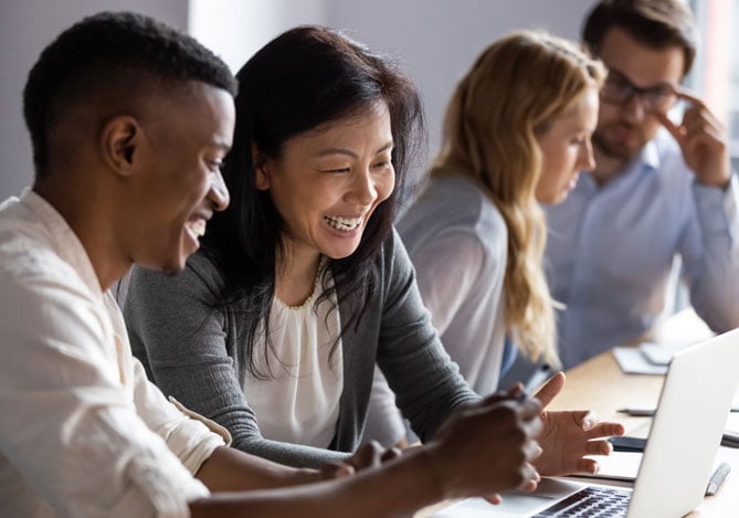 Equipe de empreendedores utilizando um sistema de gestão em um ambiente colaborativo, analisando dados no computador para melhorar a eficiência operacional.