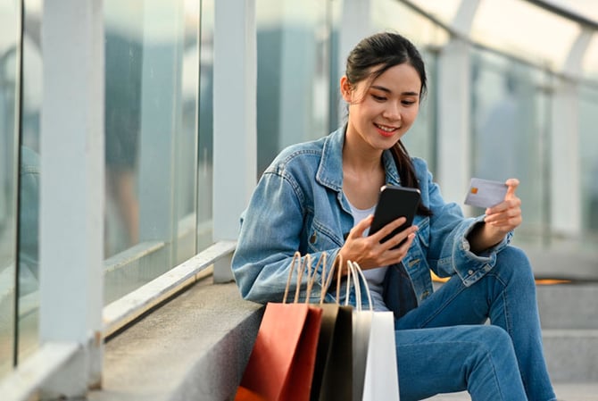 Mercado Pago: mulher sentada na calçada acompanhando as tendências de consumo