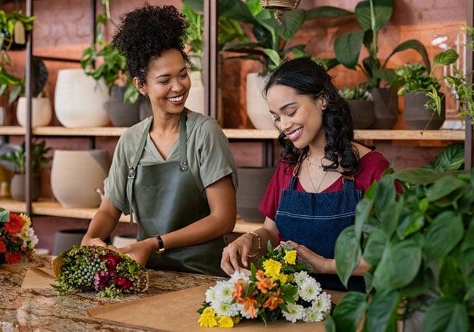Abri MEI no Mercado Pago: duas empreendedoras em oficina de flores montando buquês