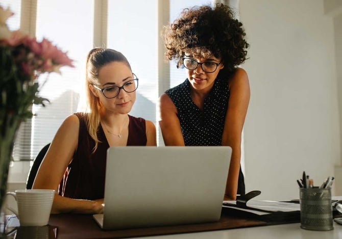 Mulheres calculando o capital de giro Mercado Pago do negócio no laptop