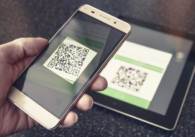 Um mão com um celular escaneando um código qr