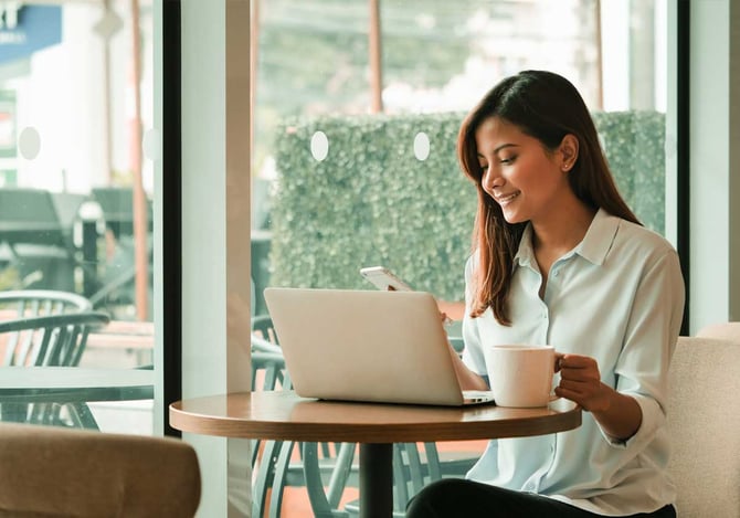 Mulher trabalhando com um notebook e uma xícara de café