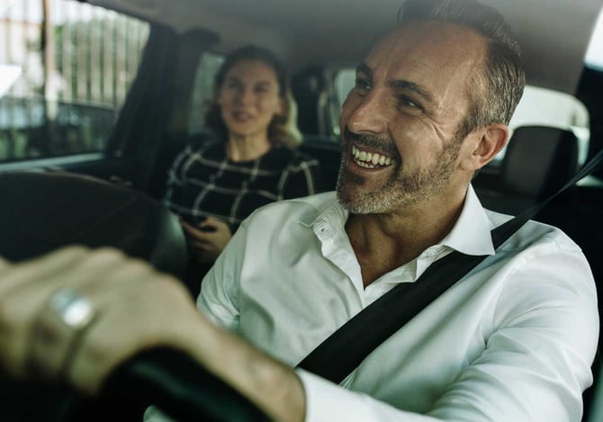 Motorista de aplicativo dirigindo e conversando com passageira