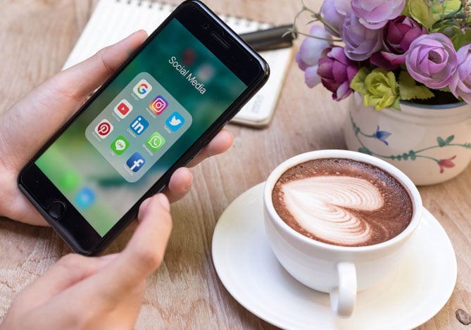 Mercado Pago: Mão de empresário segurando celular criando estratégias para vender nas redes sociais