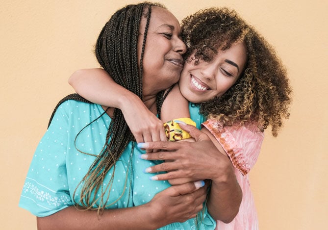 Mercado Pago: Imagem de mãe e filha sorrindo e se abraçando, representando amor e conexão familiar. Perfeita para conteúdos sobre o que vender no Dia das Mães.