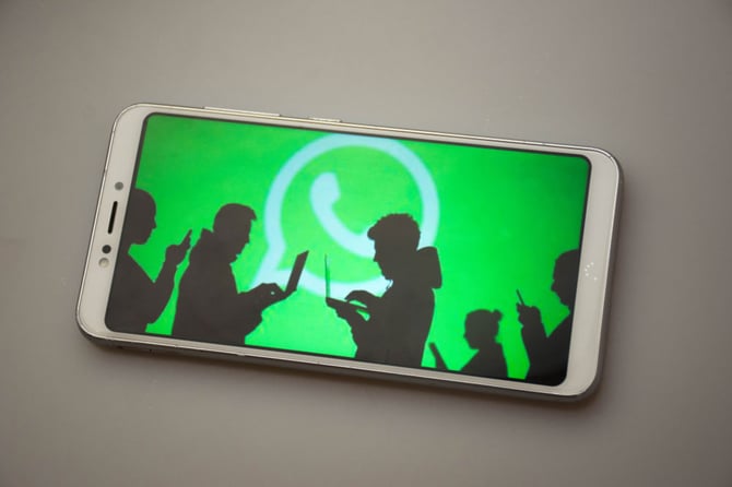 Mercado Pago: imagem ilustrativa de celular com símbolo do WhatsApp na tela e silhueta de pessoas com notebooks e celulares, simulando vendas pelo whatsapp