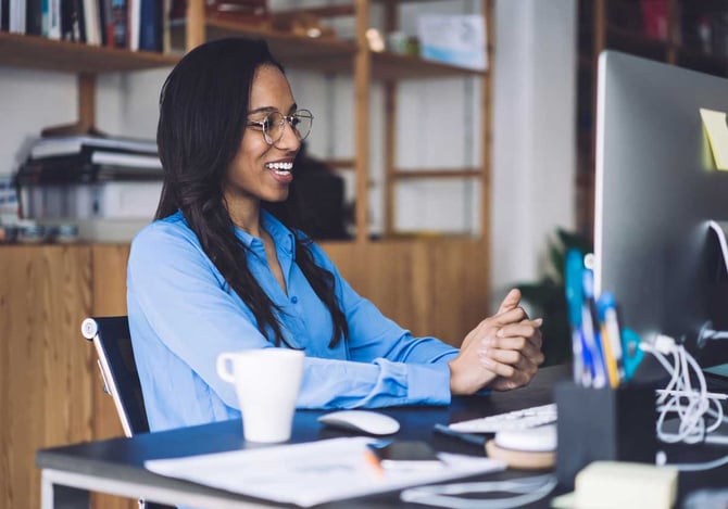 Mulher sentada em frente a uma mesa com computador