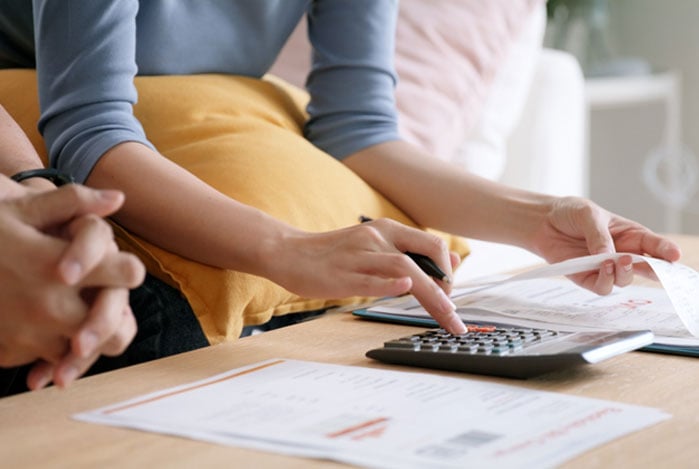 Mercado Pago: mãos de pessoas fazendo contas para definir preço do atendimento a domicílio prestado