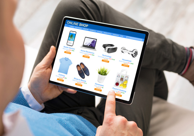 Mercado Pago: homem sentado mexendo em um tablet, com tela aberta em um e-commerce com itens comuns para o Dia dos Pais, representando o alto fluxo de vendas do período. 