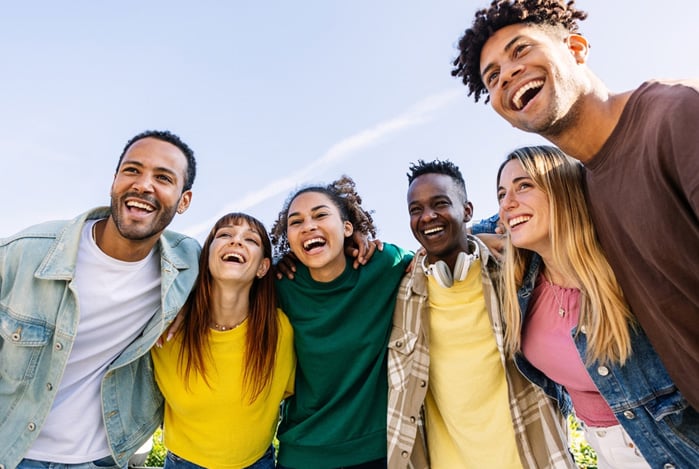 Mercado Pago: um grupo de amigos abraçados e sorrindo com a mensagem do Dia do Cliente que receberam de uma loja