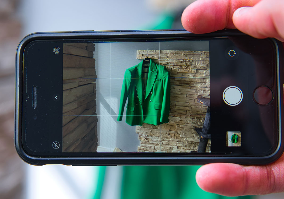 Pessoa fotografando peça de roupa com o celular para revendê-la