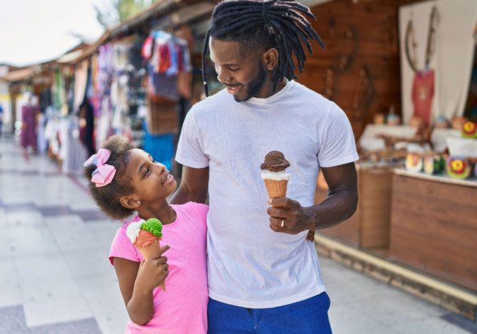 Mercado Pago: Pai e filha aproveitando as férias escolares tomando sorvete em um centro comercial