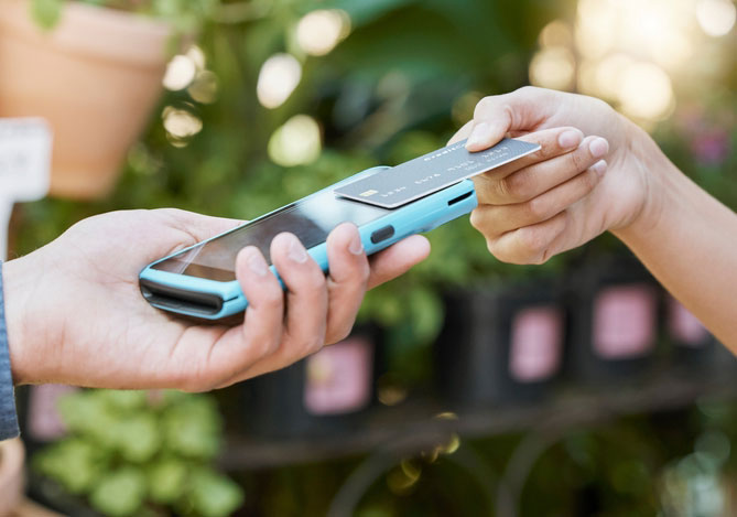 Mercado Pago: empreendedor realizando venda com seu celular para cliente que quis saber o que é NFC
