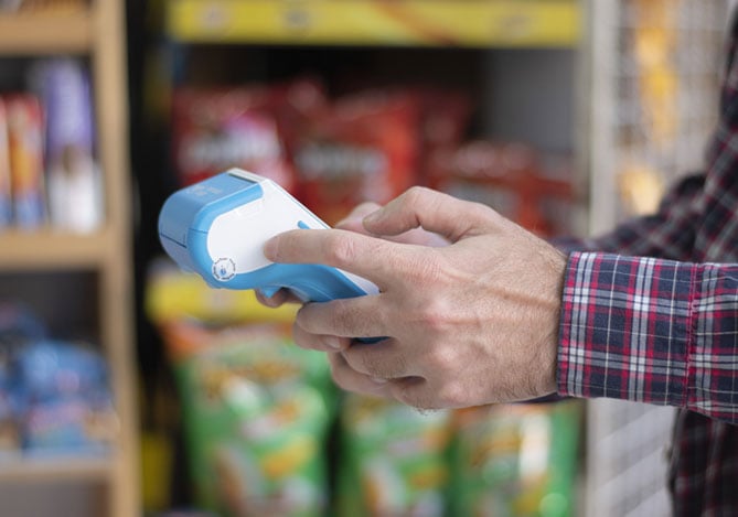 Homem realizando vendas com uma maquininha de cartão do Mercado Pago